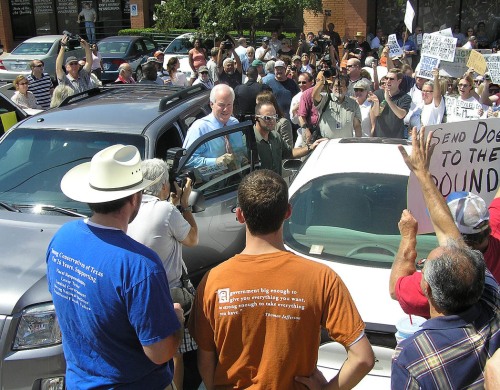 Supporters of Texas Senator John Cornyn gather around his veihicle.                                               